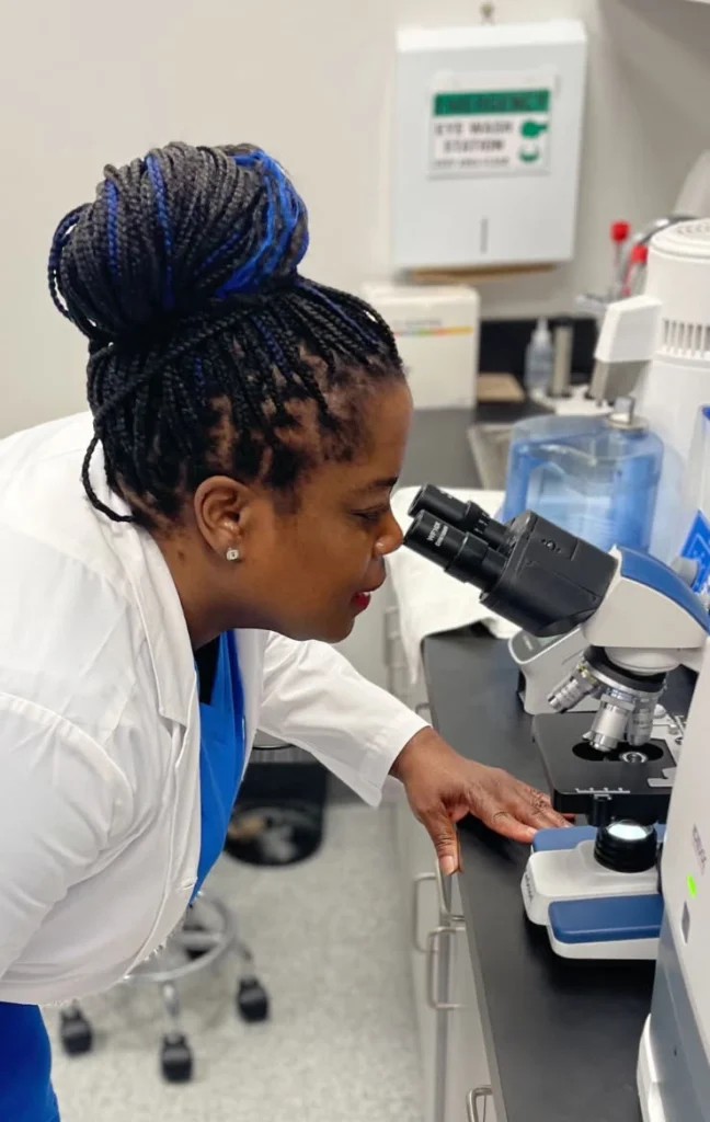 veterinary medic checking results in microscope